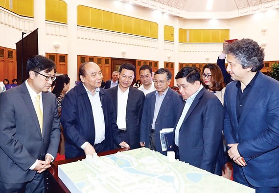 PM Nguyen Xuan Phuc (second from left) and participants examine the model of the National Innovation Centre.(Photo: VNA)