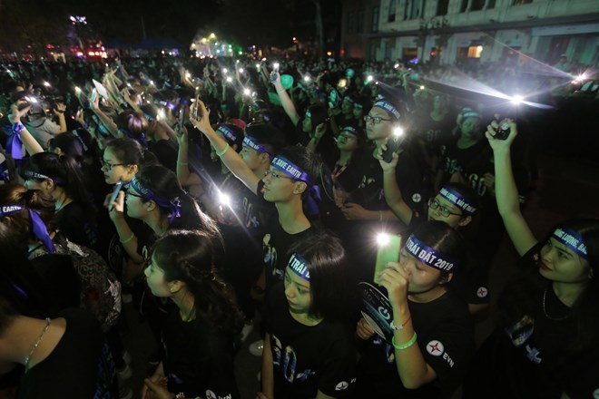 Young people take part in a ceremony responding to the Earth Hour campaign in Hanoi on March 30 evening (Photo: VNA)
