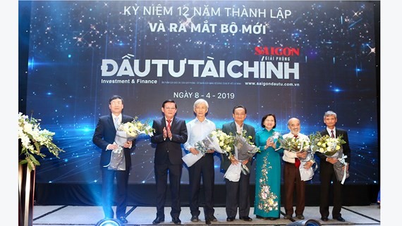 Ms. Than Thi Thu, head of HCMC Party Committee’s Propaganda and Education Board and Mr. Nguyen Tan Phong, editor in chief of Sai Gon Giai Phong Newspaper give flowers to experts at the ceremony (Photo: SGGP)