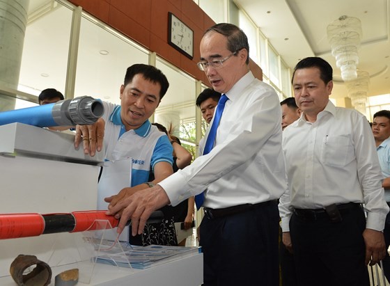 HCMC Party Chief Nguyen Thien Nhan learns about Vietnamese branded products (Photo: SGGP)