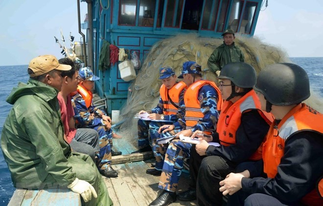 Vietnamese, Chinese coast guards inspect a Vietnamese fishing vessel in the Gulf of Tonkin (Photo: VNA)