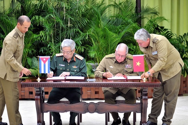 Deputy Minister of Defence Sen. Lt. Gen. Nguyen Chi Vinh and Minister of Revolutionary Armed Forces Sen. Lt. Gen. Leopoldo Cintra Frias sign minutes on implementing a dossier on the 60-year history of Vietnam-Cuba 60-year defence partnership (Photo: VNA)