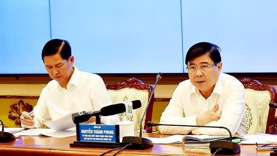 Chairman of HCMC People’s Committee Nguyen Thanh Phong (R) and his deputy Tran Vinh Tuyen at the meeting (Photo: SGGP)