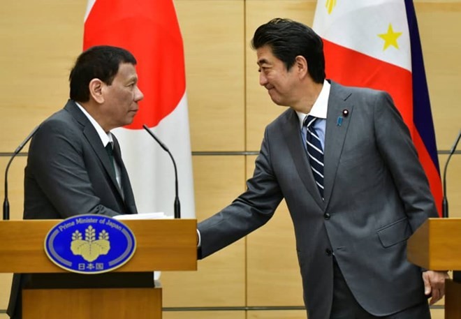 Philippine President Rodrigo Duterte (L) greets Prime Minister Shinzo Abe during a joint press statement in Tokyo on May 31 (Source: Reuters)