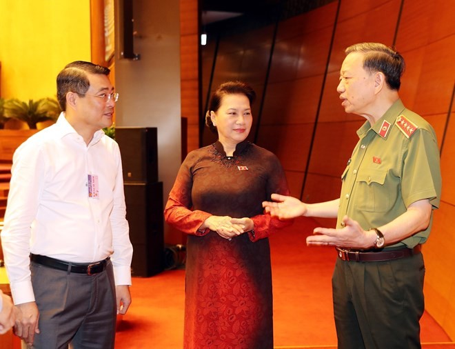NA Chairwoman Nguyen Thi Kim Ngan (centre) and Minister of Public Security To Lam (R) discuss before the session begins (Photo: VNA)