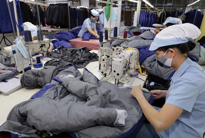 Workers produce apparel for export at the factory of the Duc Giang garment company in Long Bien district, Hanoi (Photo: VNA)