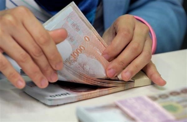 The baht notes are counted at the Krungthai Bank in Bangkok (Illustrative image. Photo: AFP/VNA)