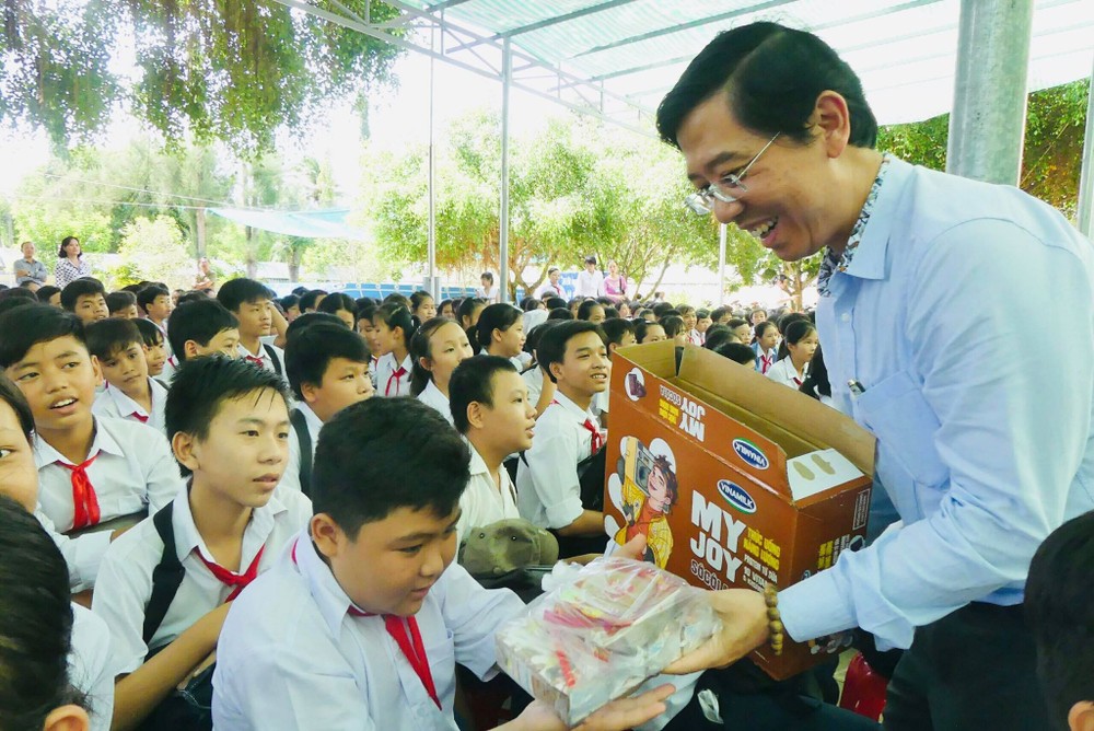 Journalist Nguyen Nhat, Deputy Editor-in-chief of SGGP Newspaper, gives students presents (Photo: SGGP)