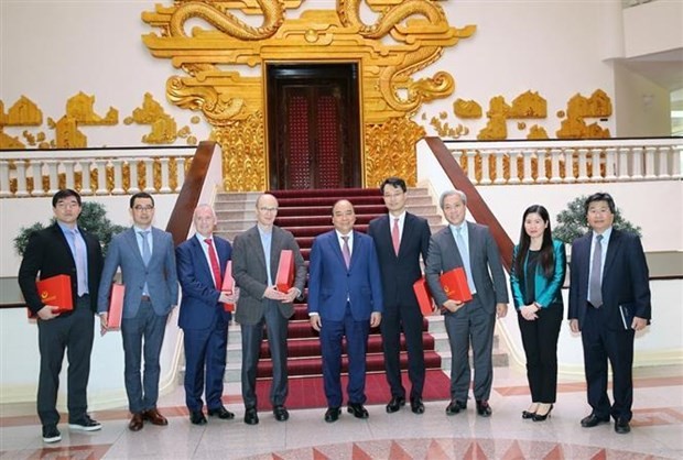 Prime Minister Nguyen Xuan Phuc (centre) poses for a group photo with foreign investors (Photo: VNA)