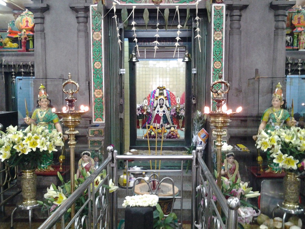 In the center is the shrine of the Goddess Mariamman and in a relief above the shrine the goddess is seated with the gods Ganesha and Naaga on either side.