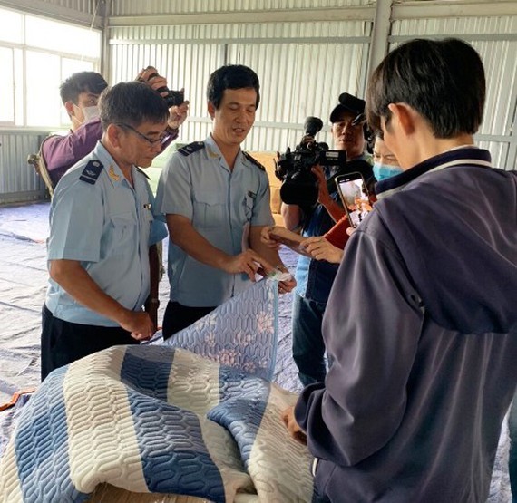 Customs officials inspect a consignment of Chinese goods with fake Vietnamese origin at Cat Lai seaport, HCMC on November 2 (Photo: SGGP)