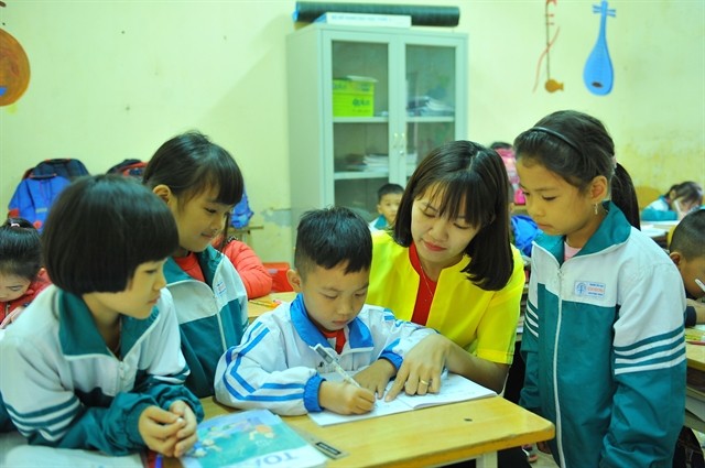 A teacher and first graders at Cuc Phuong Primary School in the northern province of Ninh Binh's Nho Quan District during a mathematics class. (Photo: VNA/VNS)