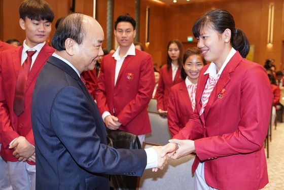 Prime Minister Nguyen Xuan Phuc shakes hands with swimmer Nguyen Thi Anh Vien (right) who wins six gold medals at the 30th SEA Games in the Philippines (Photo: VGP)