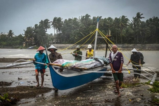 Fishermen carry a boat to higher ground in Baybay, eastern Samar on December 24 after typhoon Phanfone hit the central Philippines (Source: AFP)
