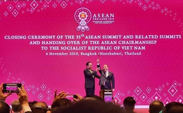 PM Nguyen Xuan Phuc receives the chairmanship gavel from his Thai counterpart Prayut Chan-o-cha at the closing ceremony of the 35th ASEAN Summit in Bangkok in November last year. (Photo: vietnamfinance.vn)