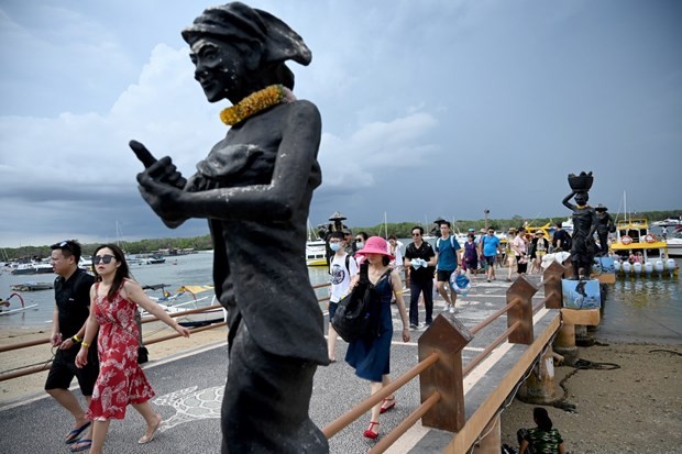 Chinese tourists, some wearing facemasks as a preventative measure following a coronavirus outbreak that began in the Chinese city of Wuhan, walk after arriving from Nusa Penida at the fast boat pier on Serangan Island in Denpasar, Bali(Source:AFP)
