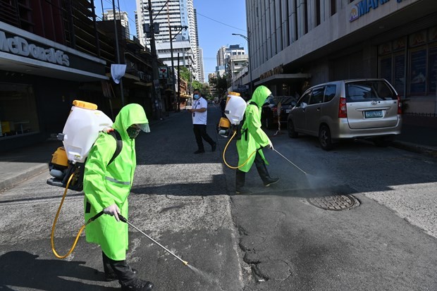 Workers disinfect an area in Manila, the Philippines, on March 19 to help curb the spread of COVID-19 (Photo: AFP/VNA)