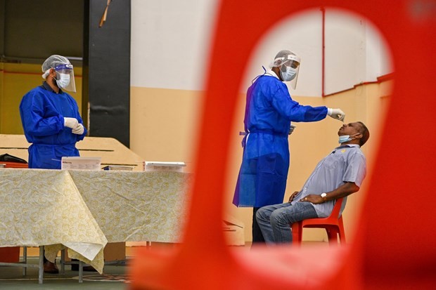 Medical workers take samples for COVID-19 testing in Kuala Lumpur, Malaysia, on January 18 (Photo: Xinhua/VNA)