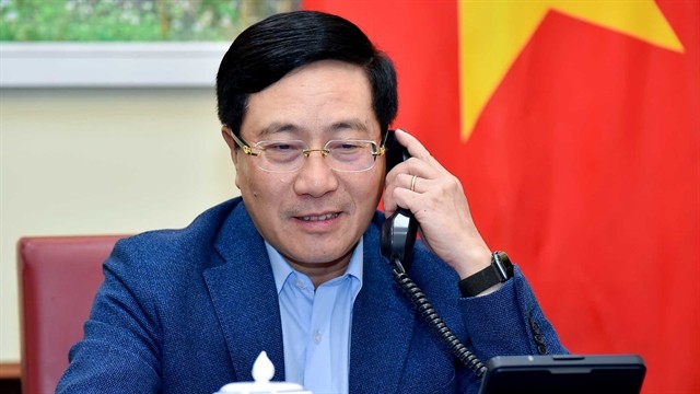 Deputy Prime Minister and Foreign Minister Pham Binh Minh during a phone call with Singaporean Foreign Minister Vivian Balakrishnan. Photo courtesy of the Ministry of Foreign Affairs.