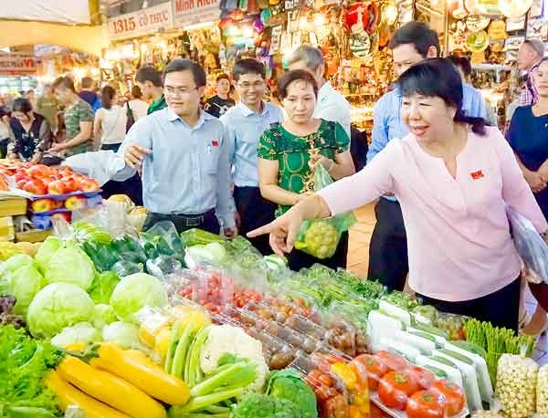 Các thành viên HĐND TPHCM khảo sát tại một quầy bán rau củ quả ở chợ Bến Thành vào tháng 2-2017. Ảnh tư liệu