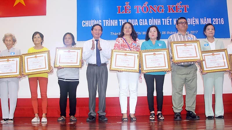 Bà Trịnh Thị Tròn (thứ 2 từ phải sang) nhận Bằng khen của UBND TPHCM tặng các hộ gia đình thực hiện tốt chương trình tiết kiệm điện