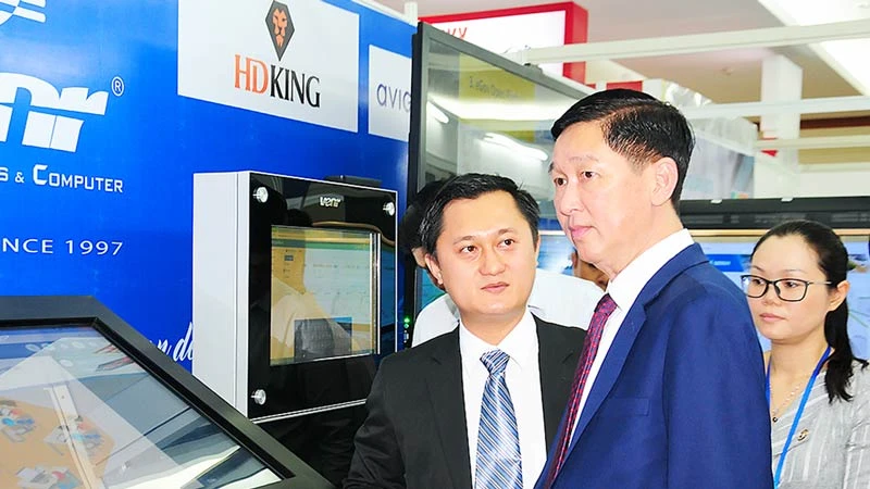 Phó Chủ tịch UBND TPHCM Trần Vĩnh Tuyến (giữa) tham quan gian hàng trưng bày của Công ty Điện tử Cây Tre Việt