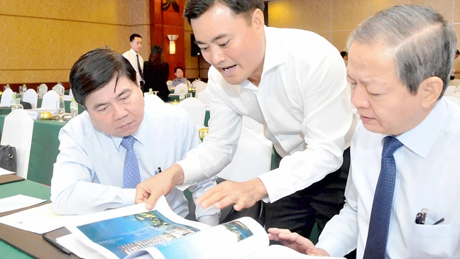 Chủ tịch UBND TPHCM Nguyễn Thành Phong xem một phác thảo công trình xây dựng tại hội nghị Ảnh: CAO THĂNG