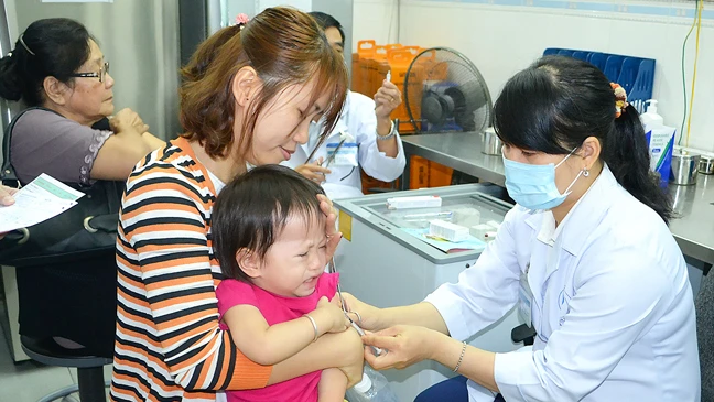 Phụ huynh đưa con đến tiêm vaccine phòng bệnh dại tại Viện Pasteur TPHCM ảnh: HOÀNG HÙNG