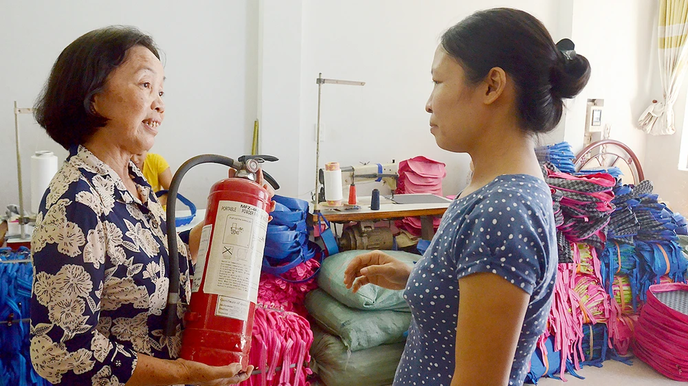 Cô Bùi Thị Khánh, Trưởng khu phố 13, phường 12, quận Gò Vấp, hướng dẫn người dân sử dụng bình chữa cháy