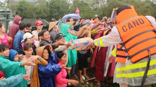 Cảnh sát Đường thủy Công an tỉnh Thừa Thiên - Huế trao quà cứu trợ người dân vùng lũ cuối nguồn sông Hương Ảnh: Văn Thắng