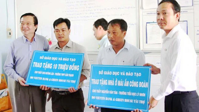 Giám đốc Sở GD-ĐT TPHCM Lê Hồng Sơn (bìa trái) trao nhà tình nghĩa cho giáo viên hoàn cảnh khó khăn ở huyện Cần Giờ