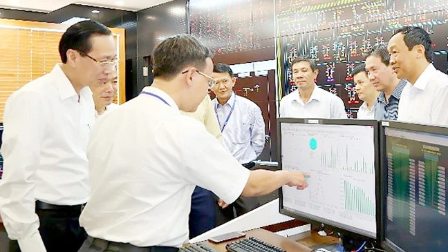 Đồng chí Lê Thanh Liêm nghe các nhân viên trực vận hành tại Trung tâm Điều độ hệ thống điện TPHCM báo cáo tình hình
