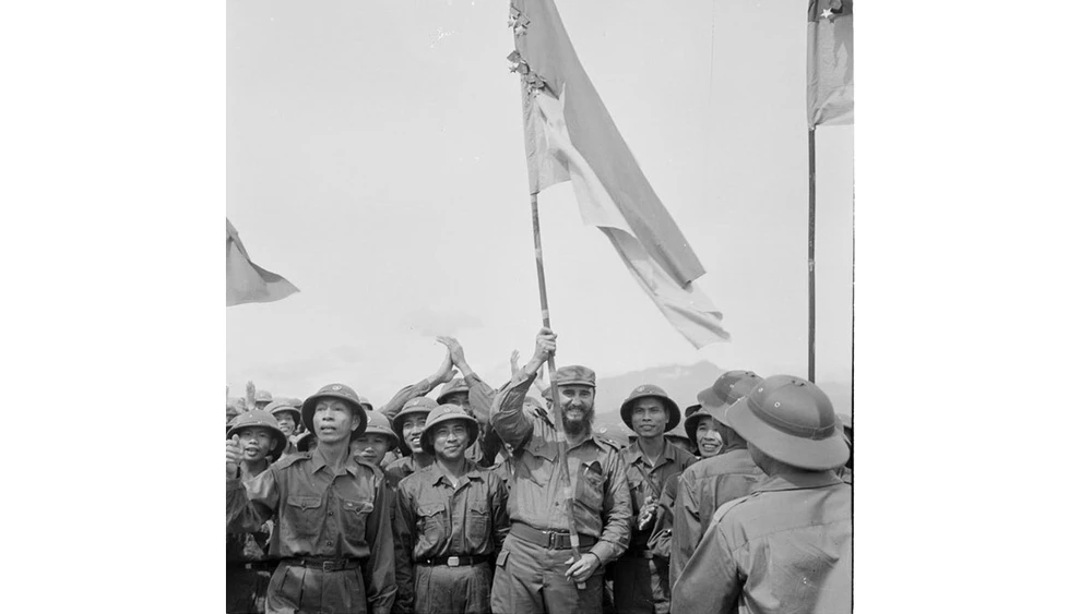 Fidel Castro giương cờ truyền thống của Đoàn Khe Sanh, Quân giải phóng Trị Thiên Huế trong chuyến thăm VN ngày 15-9-1973. Ảnh tư liệu TTXVN