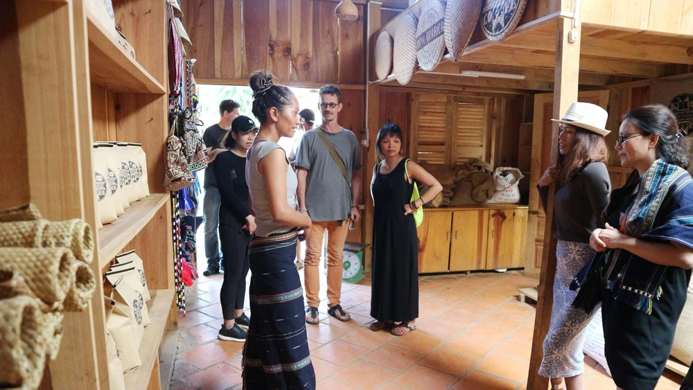 Du khách tham quan gian trưng bày sản phẩm dệt thổ cẩm, cà phê arabica của người K’Ho dưới chân núi Langbiang