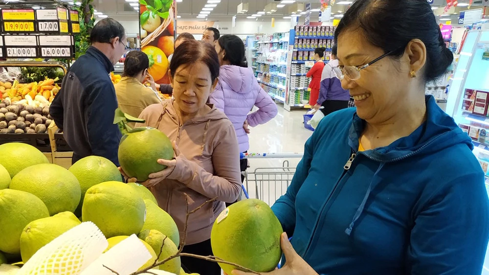 Khách hàng chọn mua trái cây bình ổn giá tại siêu thị Co.opmart Ảnh: CTV