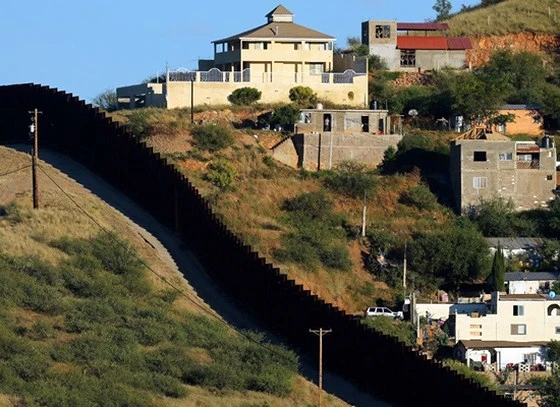Tường rào biên giới giữa 2 TP Nogales: Nogales ở bang Sonora của Mexico (phải) và Nogales ở bang Arizona của Mỹ. Ảnh: REUTERS
