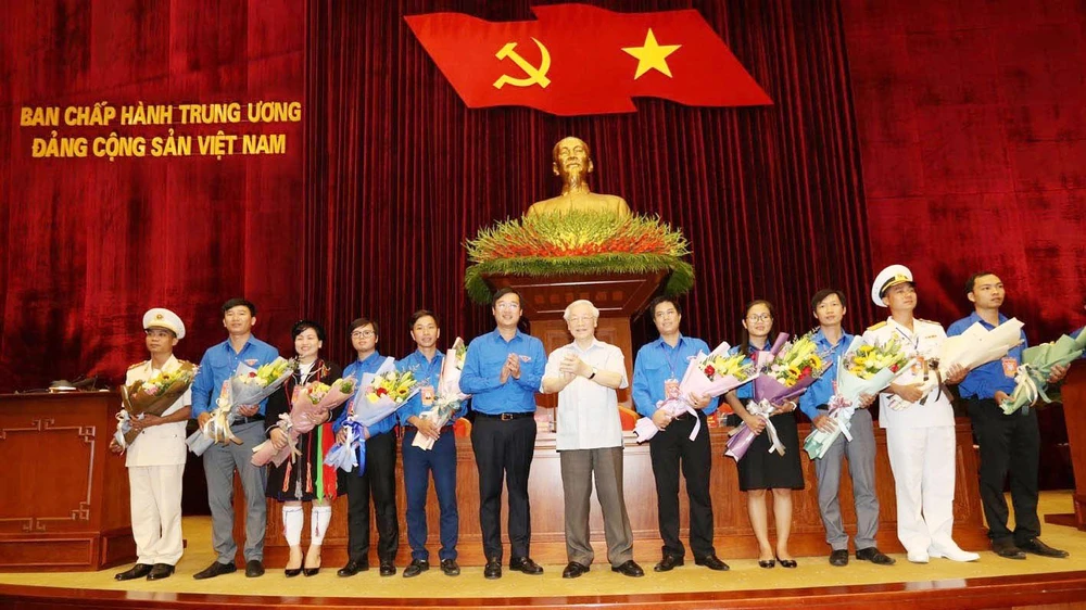 Tổng Bí thư, Chủ tịch nước Nguyễn Phú Trọng tặng hoa các đảng viên trẻ tiêu biểu. Ảnh: TTXVN