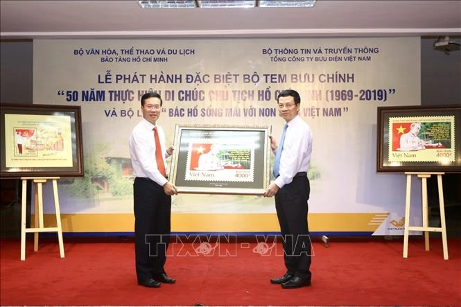 Bộ trưởng Bộ Thông tin và Truyền thông Nguyễn Mạnh Hùng (phải) tặng bức tem cho Trưởng Ban Tuyên giáo Trung ương Võ Văn Thưởng. Ảnh: TTXVN