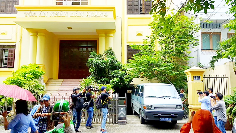 Xe của Công an quận 1 rời khỏi TAND quận 4 sau khi khám xét nơi làm việc của ông Nguyễn Hải Nam. Ảnh: KHÁNH QUỲNH