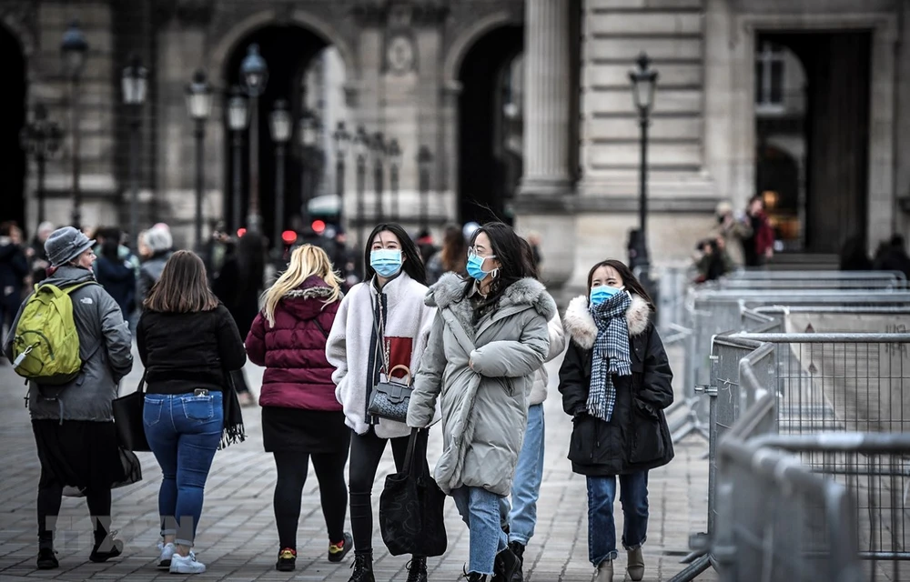 Người dân và du khách đeo khẩu trang phòng tránh lây nhiễm COVID-19 tại Paris, Pháp. Ảnh: AFP/TTXVN