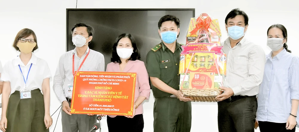 Đồng chí Nguyễn Thị Thu Hoài (thứ 3 từ trái sang) tặng quà Ban giám đốc Trung tâm Kiểm soát bệnh tật TPHCM