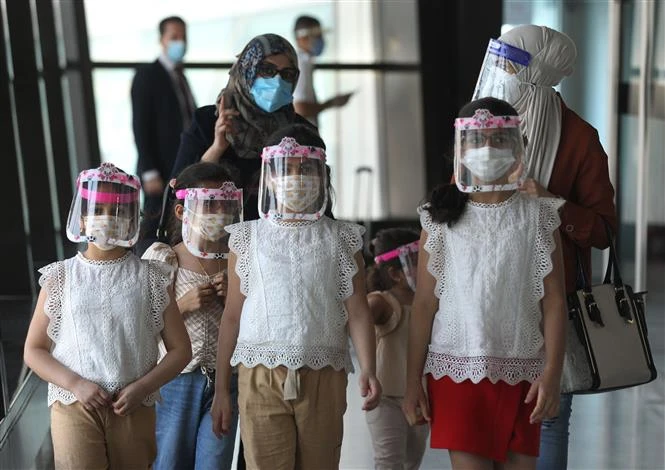 Một gia đình người Iraq đeo khẩu trang và tấm chắn che mặt để phòng lây nhiễm COVID-19 tại sân bay quốc tế ở Baghdad, ngày 23-7. Ảnh: AFP/TTXVN