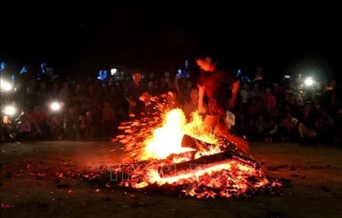 Những thanh niên người Dao Đỏ nhảy vào giữa đống lửa đang cháy bằng đôi chân trần trong sự ngạc nhiên của người xem. Ảnh: TTXVN