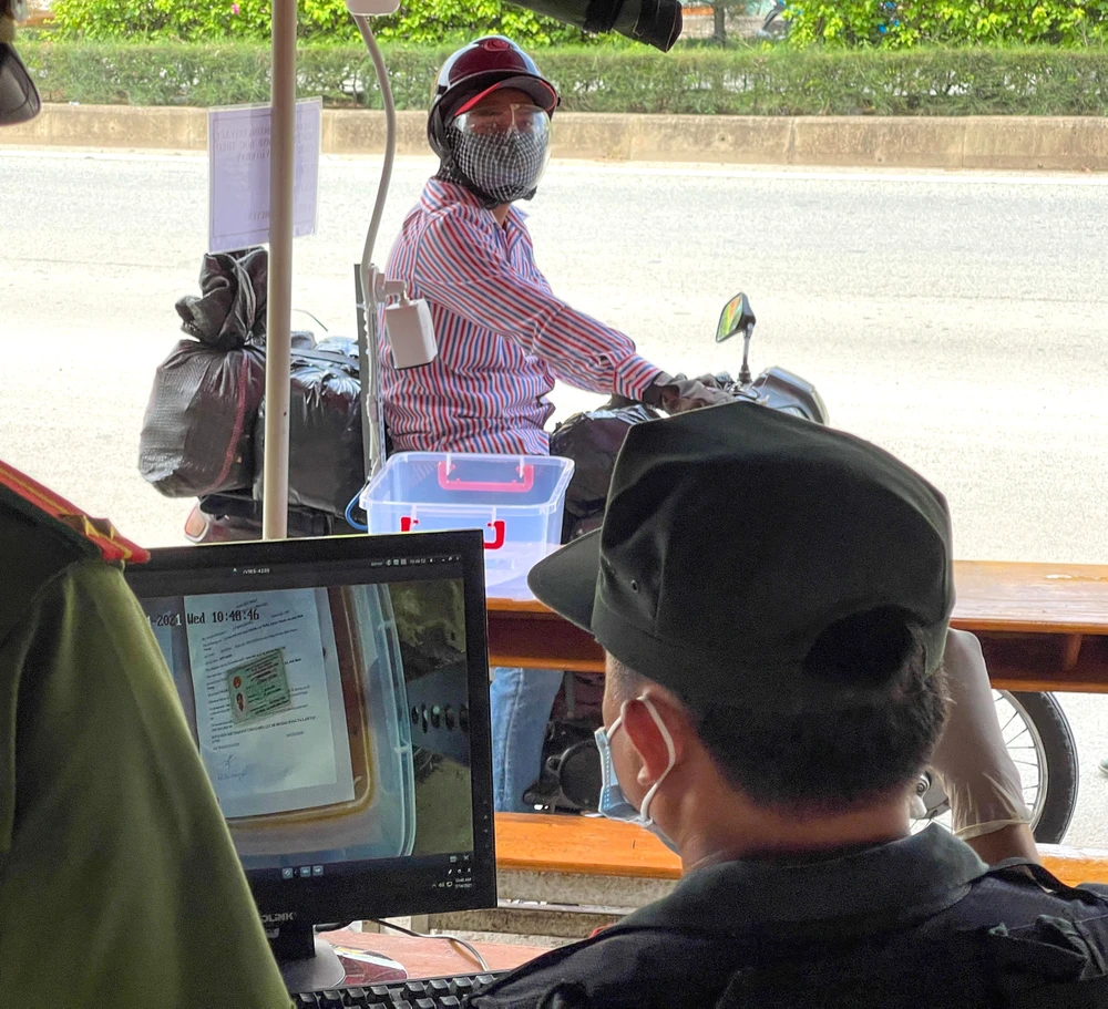 Kiểm tra giấy tờ “không chạm” bằng camera tại chốt kiểm soát dịch đầu cầu Phú Long. Ảnh: hoàng hùng