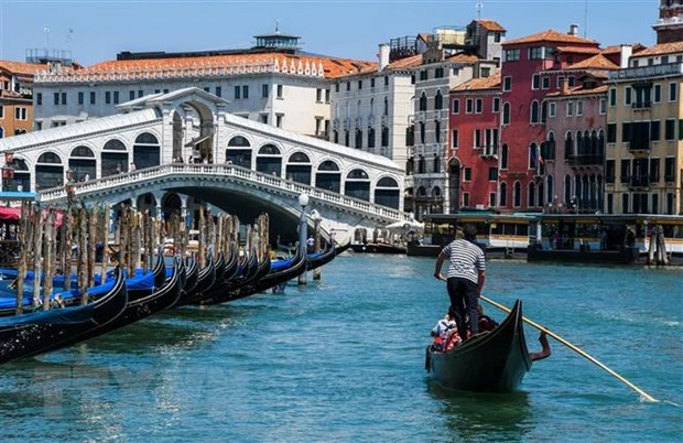 Khách du lịch đi thuyền gondola tại Venice, Italy. Ảnh: AFP/TTXVN