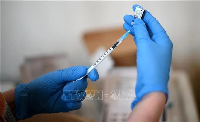 Nhân viên y tế chuẩn bị tiêm vaccine phòng COVID-19 cho người dân tại London, Anh. Ảnh: AFP/TTXVN