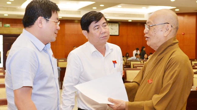 Chủ tịch UBNDTP Nguyễn Thành Phong trao đổi cùng đại biểu HĐNDTP. Ảnh: Việt Dũng