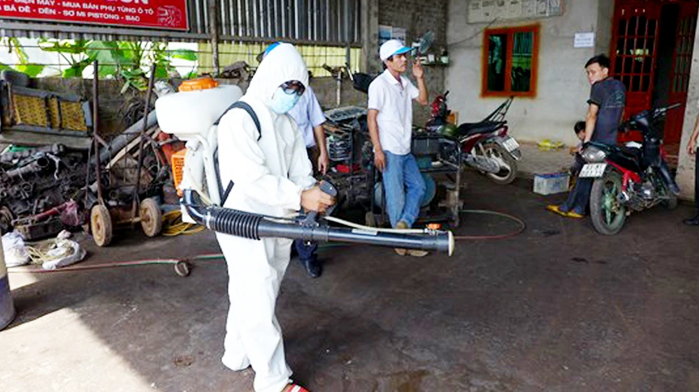  Nhân viên y tế phun thuốc diệt muỗi ngăn ngừa bệnh SXH bùng phát ở nhà dân