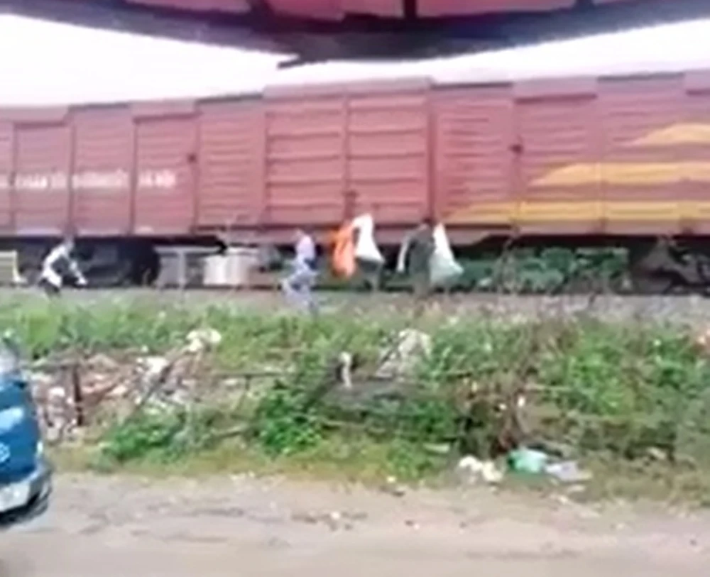 Một số người dân treo các bao rác thải lên thành toa tàu hỏa (Ảnh cắt từ clip trên facebook)