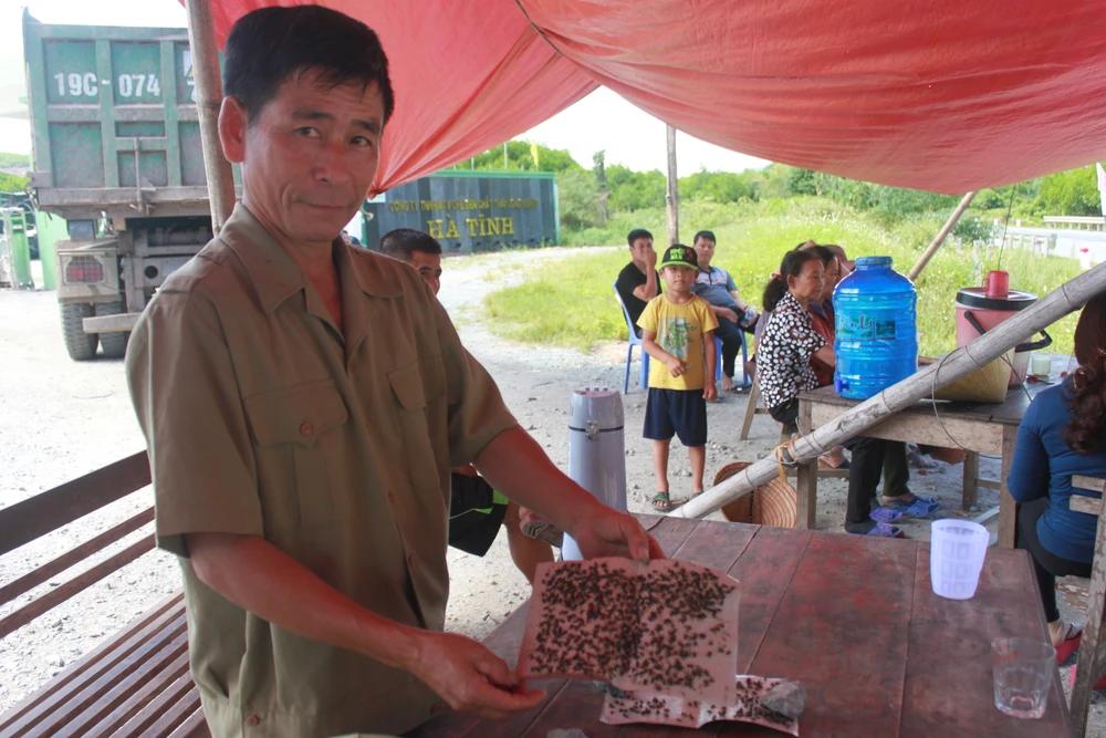 Ông Nguyễn Tiến Phừng bên các bẫy dính đầy ruồi tại cổng nhà máy xử lý rác thải để phản ánh tình trạng ô nhiễm